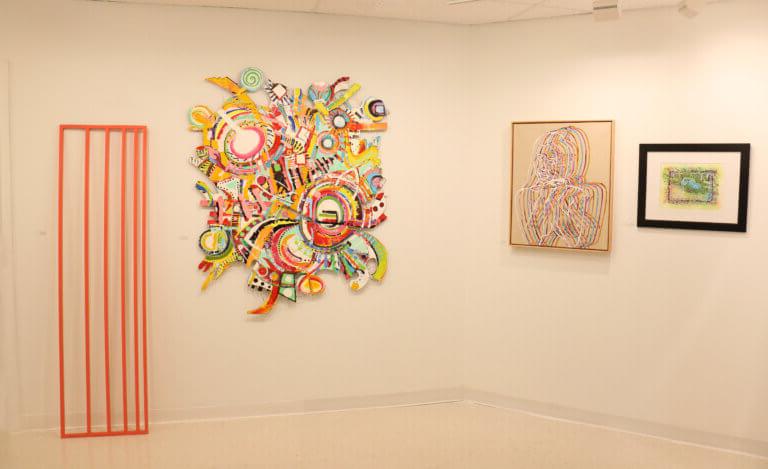 色彩鲜艳的艺术品陈列在白色的画廊空间里.